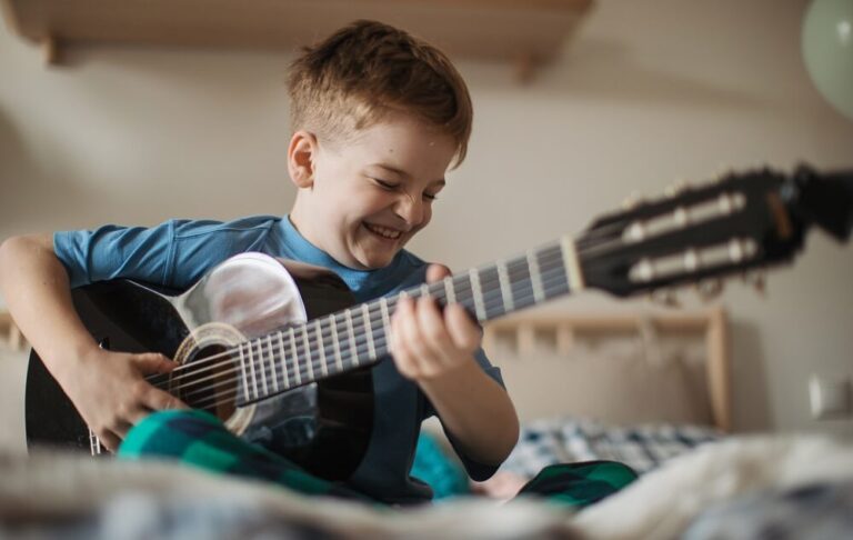 Garoto feliz tocando violão em seu quarto