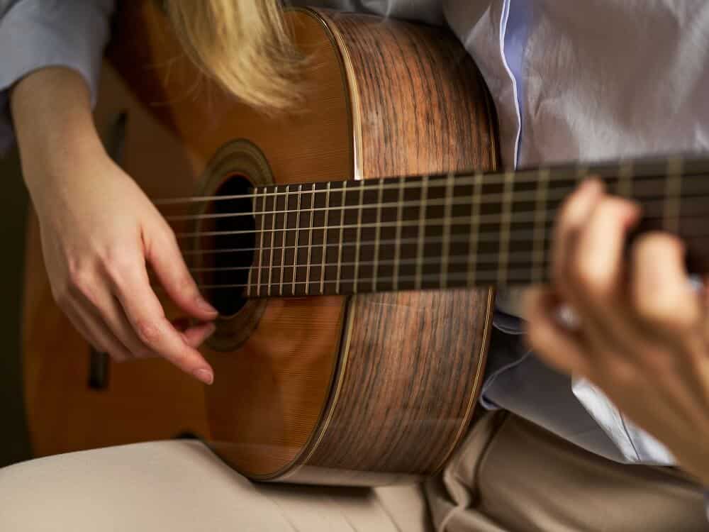 pessoa tocando violão clássico